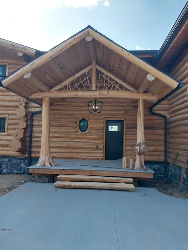 Small log cabin with a covered front entry