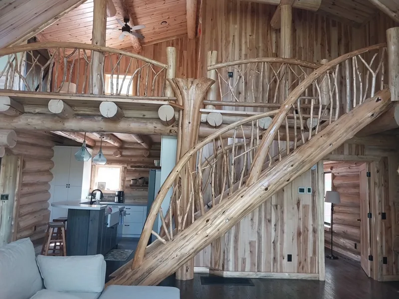 Log staircase and upper landing inside a timber home