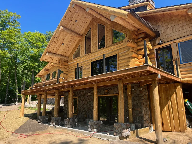 Log home with a covered porch and exposed timber roof framing