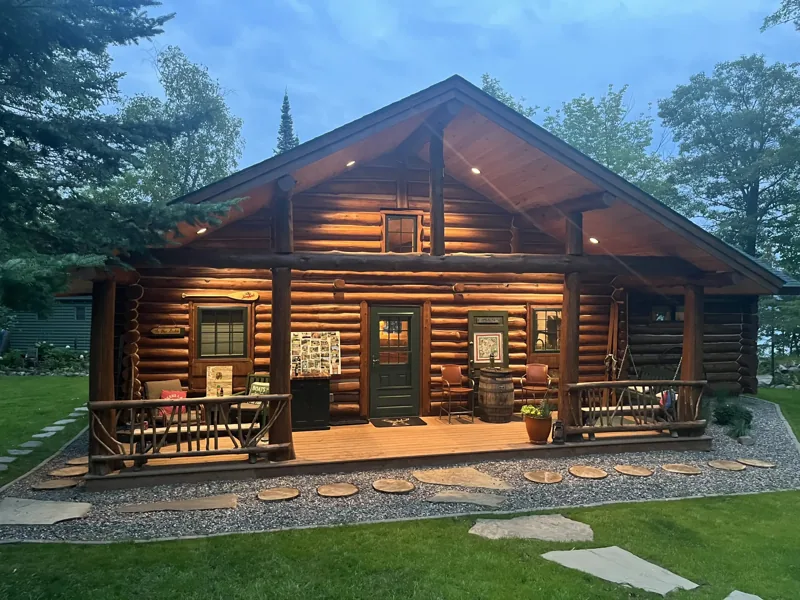 Log home with a covered porch and large front windows