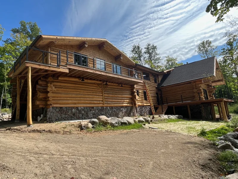 Log home with an attached garage and upper gable windows