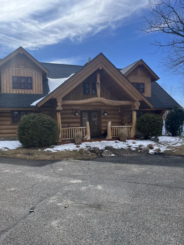 Two-story log home with gabled roofs and a deck