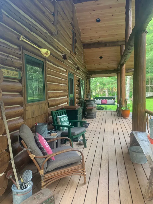 Covered cabin porch with wood decking and seating